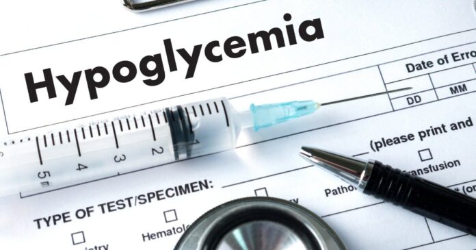 Word hypoglycemia on a diagnosis sheet with a pen and syringe